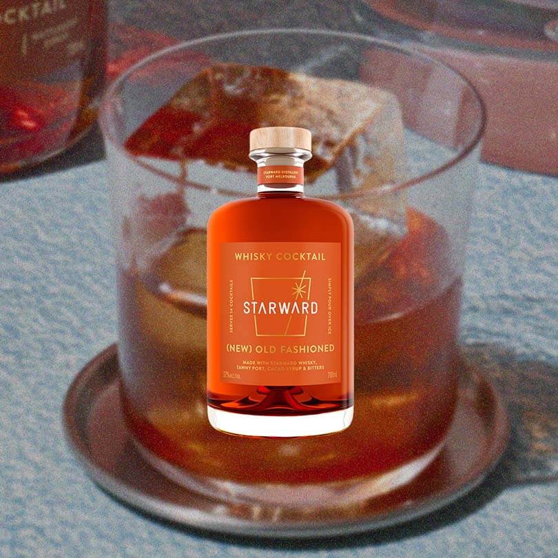 A macro shot of an Old Fashioned with a bottle of Starward's (New) Old Fashiioned Whisky Cocktail on top.