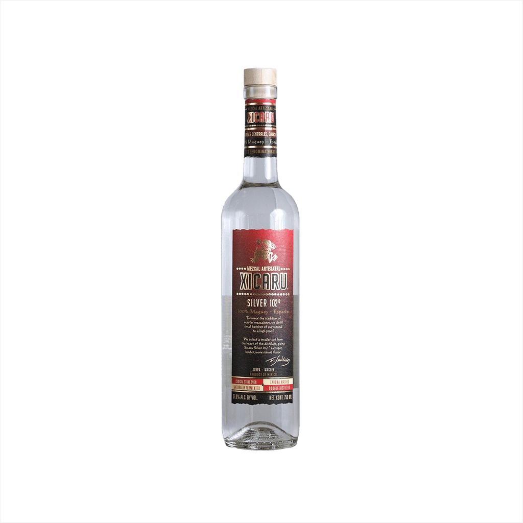A tall artesanal shaped bottle with a red label and gold writing stating: Xicaru Mexcal Silver 102 Proof