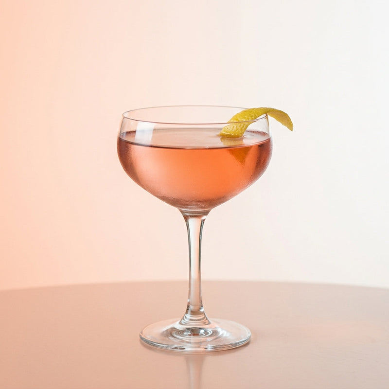 A photo of the The Low Countries Manhattan cocktail containing Bols Genever, Etter Kirsch AOP Zug Eau de Vie, Giffard Sugar Cane Syrup (Sirop Sucre de Canne), Peychaud's Bitters in a Coupe.