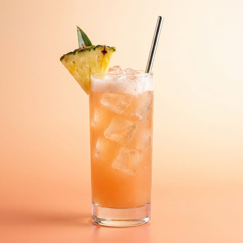 A photo of the Tropical Two-Step cocktail containing Milagro Reposado Tequila, Flor de Caña 4 Year Old Añejo Oro Rum, Freshly squeezed pink grapefruit juice, Fresh pressed pineapple juice, Giffard Sugar Cane Syrup (Sirop Sucre de Canne) in a Collins.
