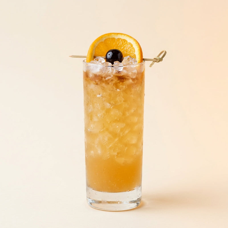 A photo of the Rum Punch cocktail containing Wray & Nephew White Overproof Rum, Freshly squeezed lime juice, Giffard Sugar Cane Syrup (Sirop Sucre de Canne), Angostura Aromatic Bitters, Chilled water in a Collins.