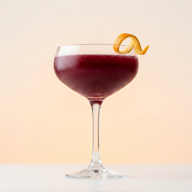 A photo of the The Cognac Coupe cocktail containing Hennessy V.S. Cognac, Freshly squeezed lemon juice, Giffard Sugar Cane Syrup (Sirop Sucre de Canne), Blackcurrant jam (preserve) in a Coupe.