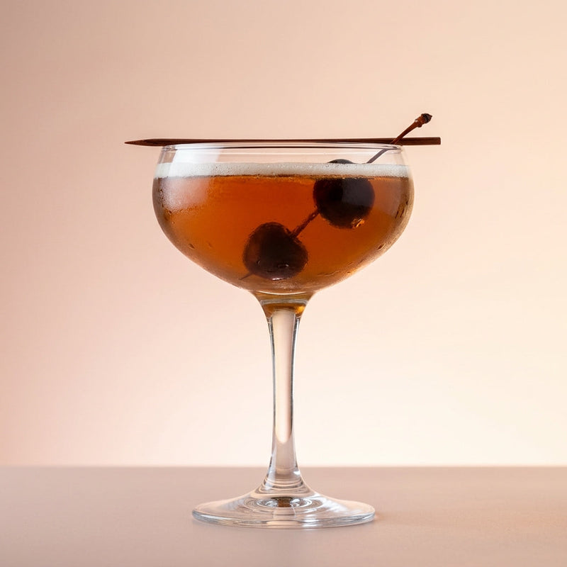 A photo of the The Bourbon Cherry Pop cocktail containing Savage & Cooke Cask Finished Bourbon, Luxardo Maraschino Liqueur, Freshly squeezed lime juice, Giffard Sugar Cane Syrup (Sirop Sucre de Canne) in a Coupe.