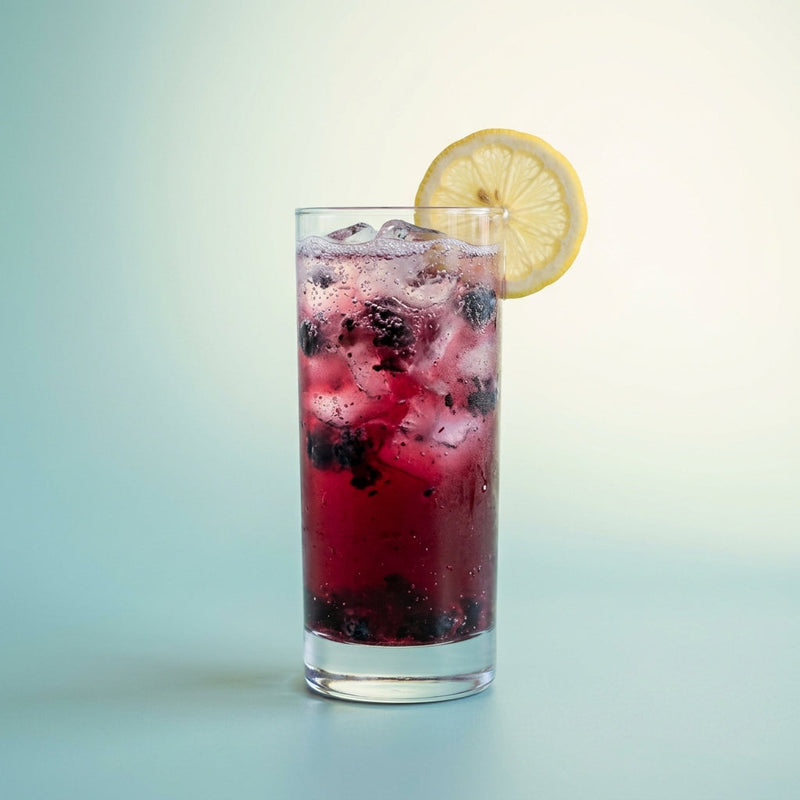 A photo of the Blueberry Rum Fizz cocktail containing Blueberries, Planteray 3 Stars White Rum, Freshly squeezed lemon juice, Giffard Sugar Cane Syrup (Sirop Sucre de Canne), Club soda in a Collins.