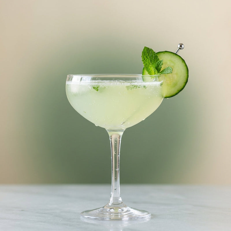 A photo of the Garden Party Gin Fizz cocktail containing English cucumber peeled, Mint leaves, Beefeater London Dry Gin, Freshly squeezed lime juice, Giffard Sugar Cane Syrup (Sirop Sucre de Canne), Club soda in a Coupe.