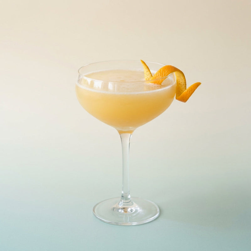 A photo of the Gin Sidecar cocktail containing Beefeater London Dry Gin, Giffard Triple Sec, Freshly squeezed orange juice, Giffard Sugar Cane Syrup (Sirop Sucre de Canne), Orange flower water in a Coupe.