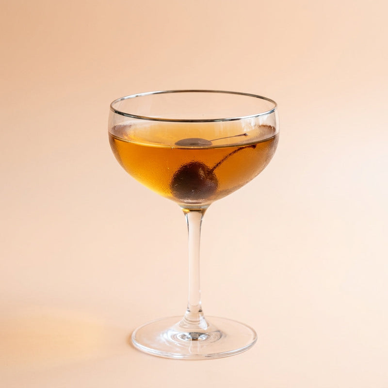 A photo of the Metropole cocktail containing Hennessy V.S. Cognac, Noilly Prat Dry Vermouth, Peychaud's Bitters, Angostura Orange Bitters, Giffard Sugar Cane Syrup (Sirop Sucre de Canne) in a Coupe.