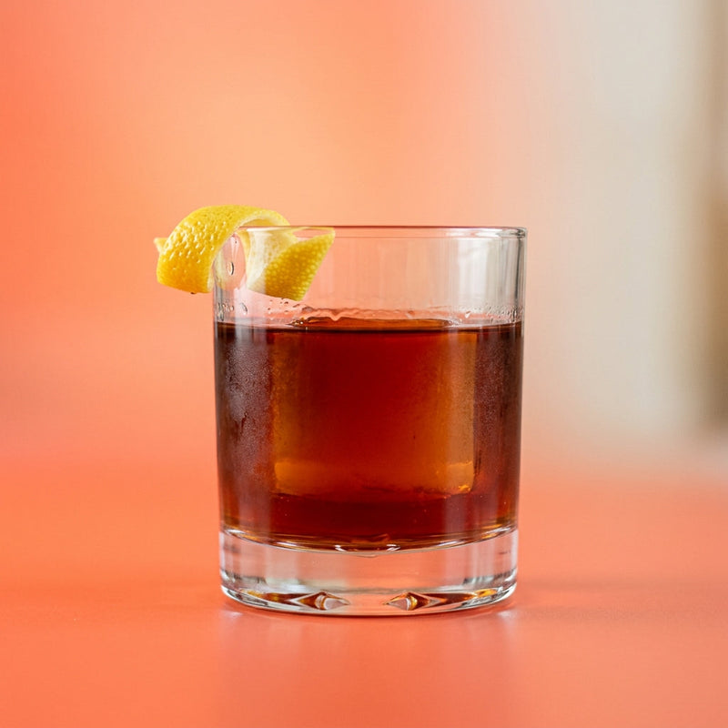 A photo of the Bourbon & Brandy Old Fashioned cocktail containing Savage & Cooke Cask Finished Bourbon, Hennessy V.S. Cognac, Liber & Co. Real Grenadine, Peychaud's Bitters, Angostura Aromatic Bitters in a Old-Fashioned.