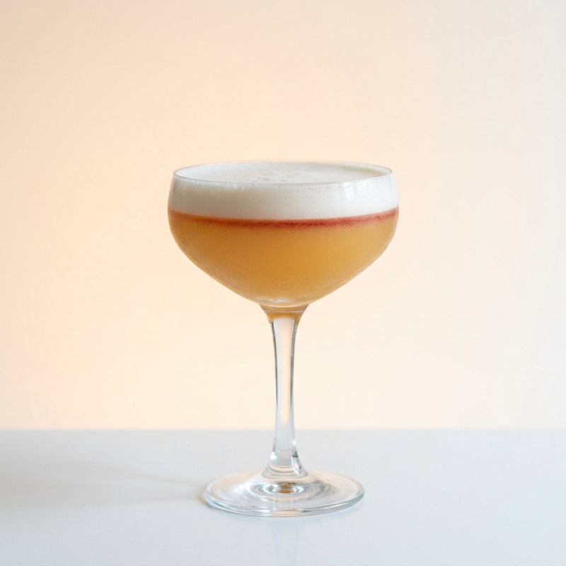 A photo of the Cognac Cloud cocktail containing Hennessy V.S. Cognac, Freshly squeezed lemon juice, Giffard Sugar Cane Syrup (Sirop Sucre de Canne), Giffard Orgeat Syrup, Fee Brothers Fee Foam Egg White Alternative in a Coupe.