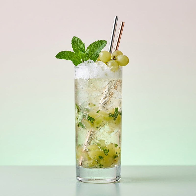 A photo of the Cognac Crush Royale cocktail containing Seedless white grapes, Mint leaves, Hennessy V.S. Cognac, Giffard Sugar Cane Syrup (Sirop Sucre de Canne), Perrier Jouet Grand Brut Champagne in a Collins.