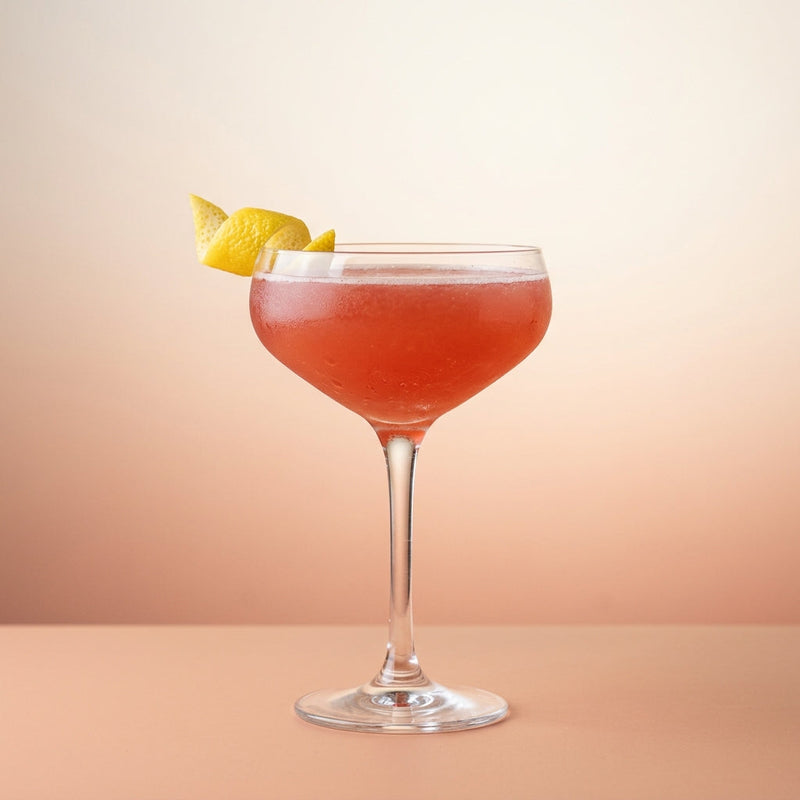 A photo of the Royal Smile cocktail containing Beefeater London Dry Gin, Roger Groult 3 Year Reserve Pays D'Auge Calvados, Freshly squeezed lemon juice, Giffard Sugar Cane Syrup (Sirop Sucre de Canne), Liber & Co. Real Grenadine in a Coupe.