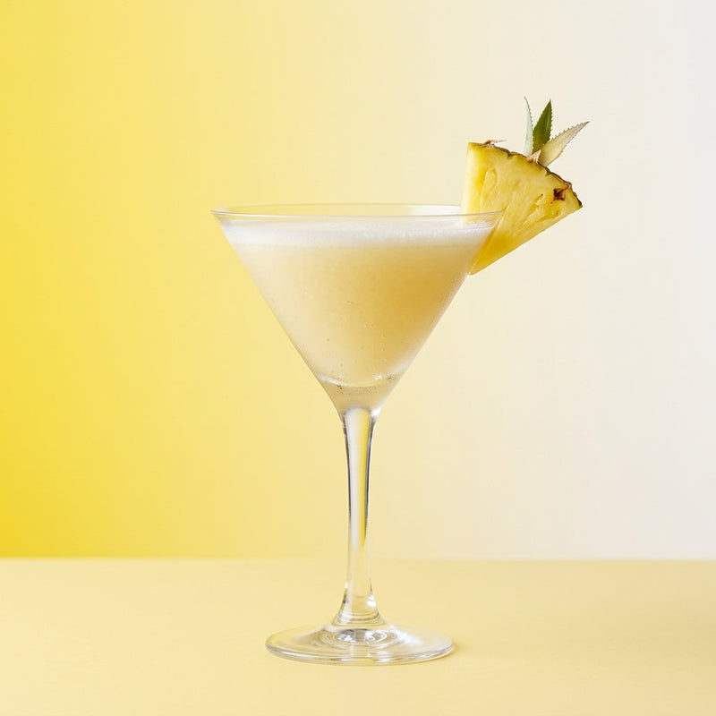 A photo of the The Flo Ziegfeld cocktail containing Beefeater London Dry Gin, Fresh pressed pineapple juice, Giffard Sugar Cane Syrup (Sirop Sucre de Canne) in a Martini.