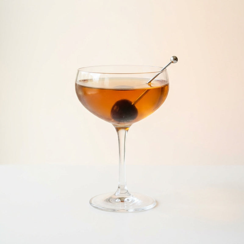 A photo of the The Parisian Persuasion cocktail containing Hennessy V.S. Cognac, Lillet Blanc Aperitif, Suze Aperitif, Giffard Sugar Cane Syrup (Sirop Sucre de Canne), Peychaud's Bitters, Angostura Aromatic Bitters in a Coupe.