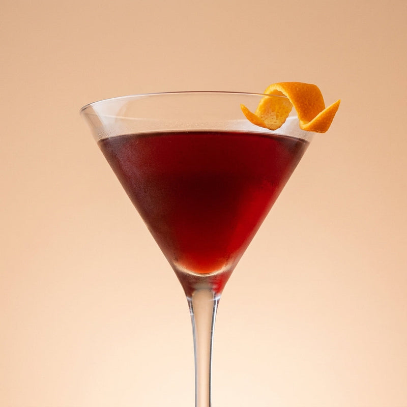 A photo of the Cherry Royal Rob Roy cocktail containing Compass Box Great King Street Artist's Blend Scotch, Dubonnet Rouge, Heering Cherry Liqueur in a Martini.