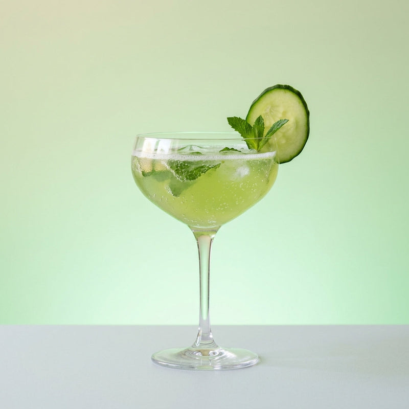 A photo of the Foggy Harbor Fizz cocktail containing Pernod Absinthe, Planteray 3 Stars White Rum, Freshly squeezed lime juice, Giffard Sugar Cane Syrup (Sirop Sucre de Canne), Mint leaves, English cucumber peeled, Club soda in a Coupe.