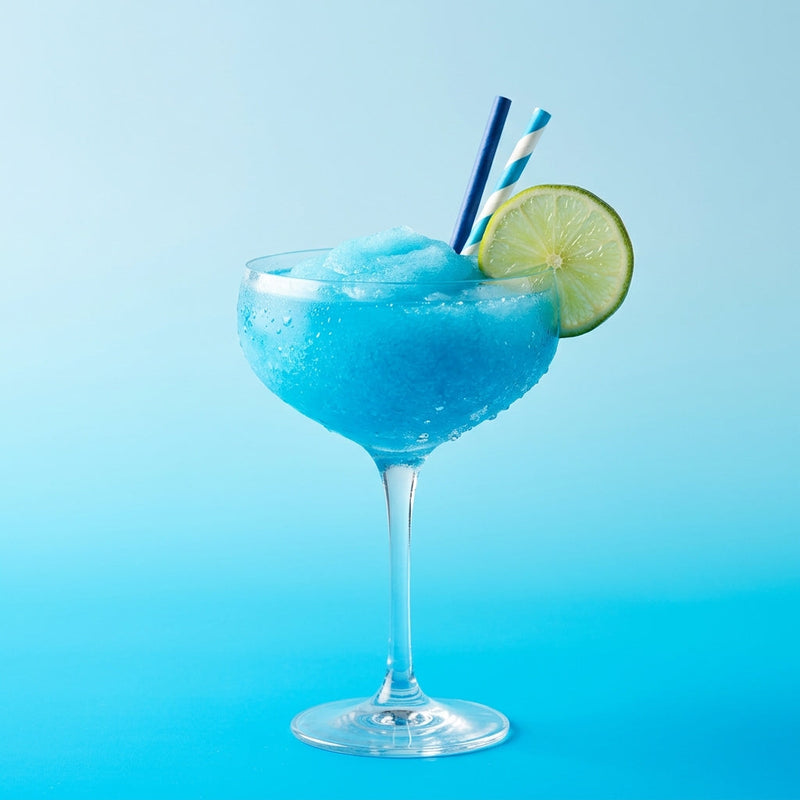 A photo of the Frozen Blue Margarita cocktail containing Milagro Reposado Tequila, Giffard Blue Curaçao, Freshly squeezed lime juice, Giffard Sugar Cane Syrup (Sirop Sucre de Canne) in a Coupe.