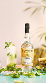 Bottle of Planteray 3 Stars rum with a mojito cocktail on a table.