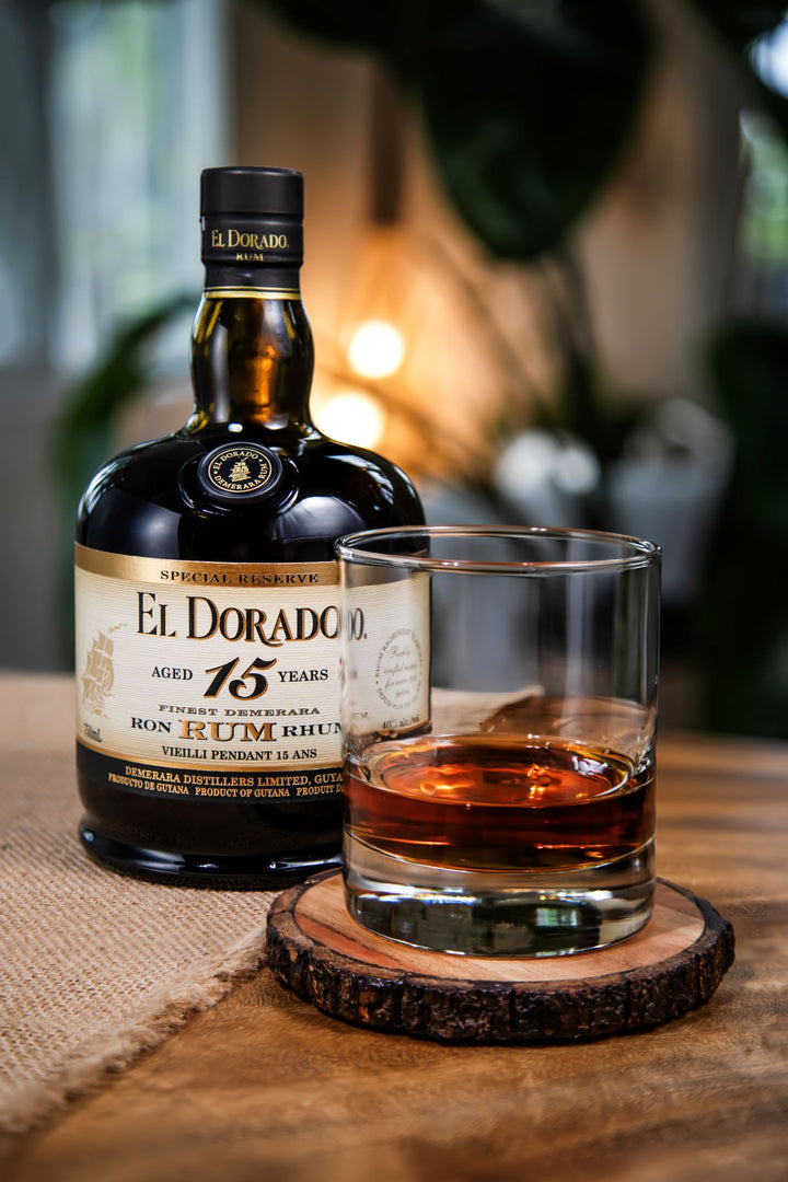 El Dorado 15-year-old rum bottle with a glass of rum on a wooden coaster.