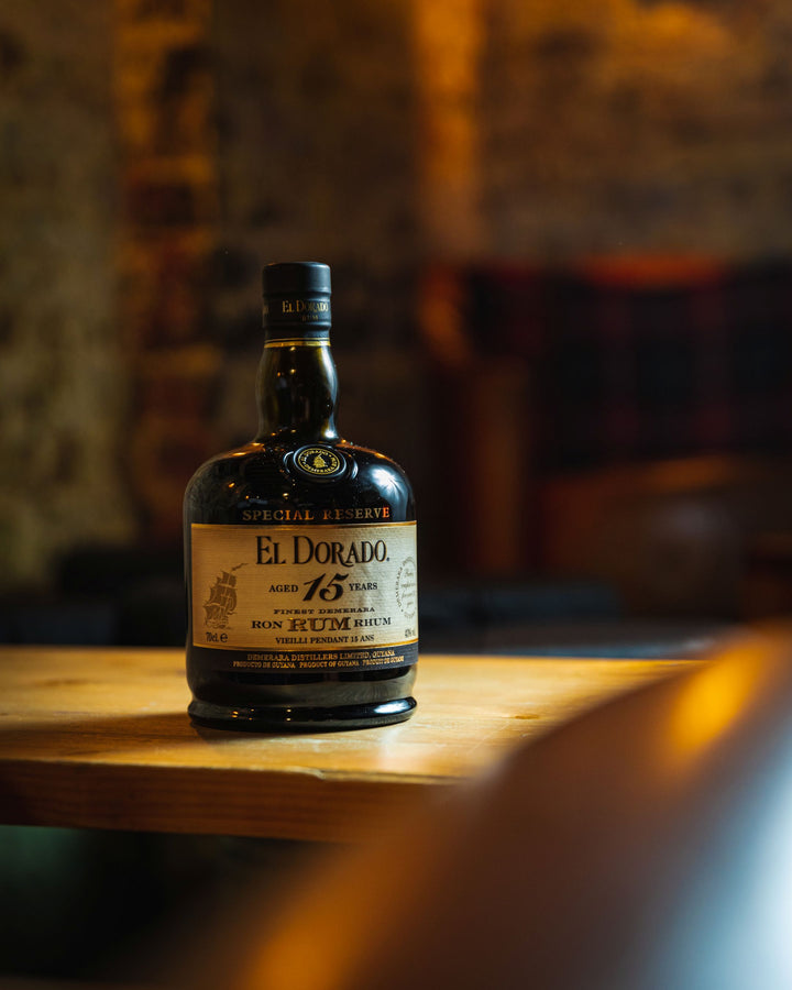 El Dorado 15 Year Rum bottle on a wooden surface with a blurred background
