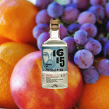 Bottle of 1615 Pisco Puro Quebranta over backdrop of fruit.