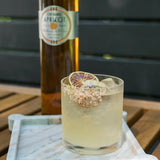 Cocktail with a bottle of Orchard Apricot wine on a wooden surface