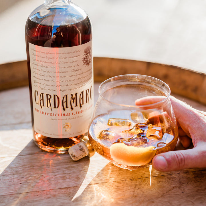 Bottle of Cardamomo liquor with a glass of the drink on a wooden surface