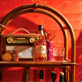 Bottle of Planteray 5 Year Rum on a bar cart with a red background