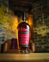 Bottle of El Dorado rum on a wooden surface with a blurred background