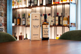 Hampden rum bottle and box on a bar counter with blurred bar background
