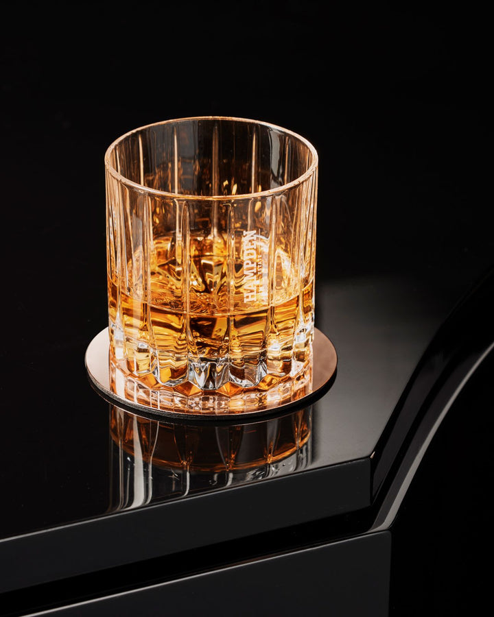Glass of rum on a black surface with a dark background