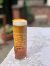 Glass with a layered drink on a table with a blurred background