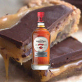 Bottle of Angostura 7 Year Old Rum over back drop of chocolate baked goods.