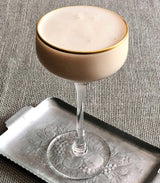 Cocktail in a glass with a textured surface on a gray background