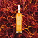 Bottle of Apologue Saffron Liqueur over back drop image of saffron.