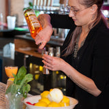 Woman bartender making a cocktail.