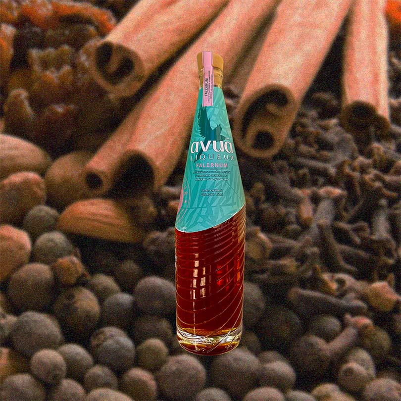 Bottle of Avuá Falernum over backdrop if spices.