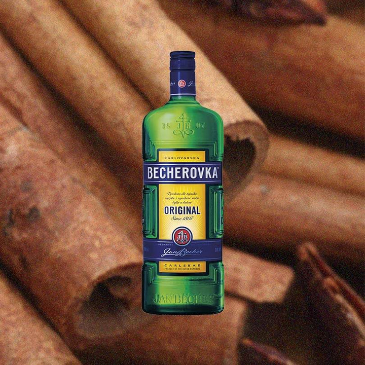 Bottle of Becherovka Herbal Liqueur over back drop of spices.