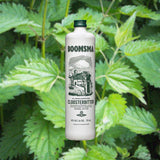 Bottle of Boomsma Claerkampster Clooster Bitter Liqueur over backdrop of green leaves.