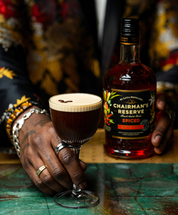 Bottle of Chairman's Reserve Spiced Rum on a table next to a coffee cocktail being served.