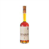 A tall bottle with a thin neck. The liquid is a pleasing orange yellow color. The label looks like old-fashioned manuscript and reads: Cardamaro.  There is a hand-drawn image of a thistle in the upper right corner. 