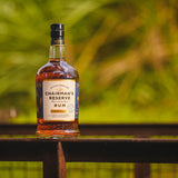 Chairman's Reserve Rum bottle on a wooden surface with a blurred green background