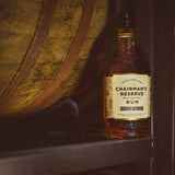 Chairman's Reserve Rum bottle in front of a wooden barrel