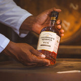 Hand holding a bottle of Chairman's Reserve Rum with a blurred background