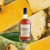 Bottle of Chairman's Reserve Legacy Rum over backdrop image of sliced Pineapple.