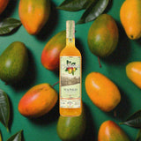 Bottle of Chinola Mango Liqueur over back drop image of mangos.