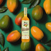 Bottle of Chinola Mango Liqueur over back drop image of mangos.