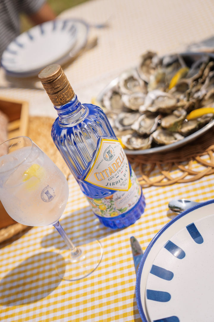 Liquor bottle with a cocktail glass on a table with oysters
