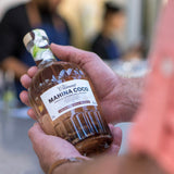 Hand holding a bottle of Mahina Coco rum with a blurred background
