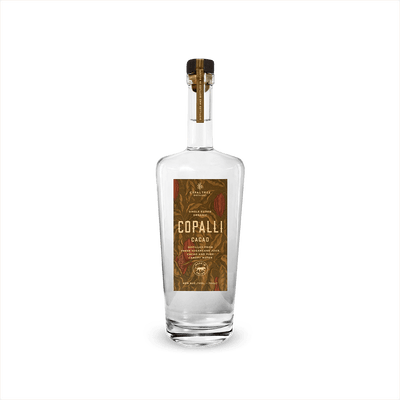 A tall elegant bottle of clear rum with a label that reads Copalli Cacao Single Estate Organic. The label, rich browns and reds, depicts cacao leaves and beans in illustration.