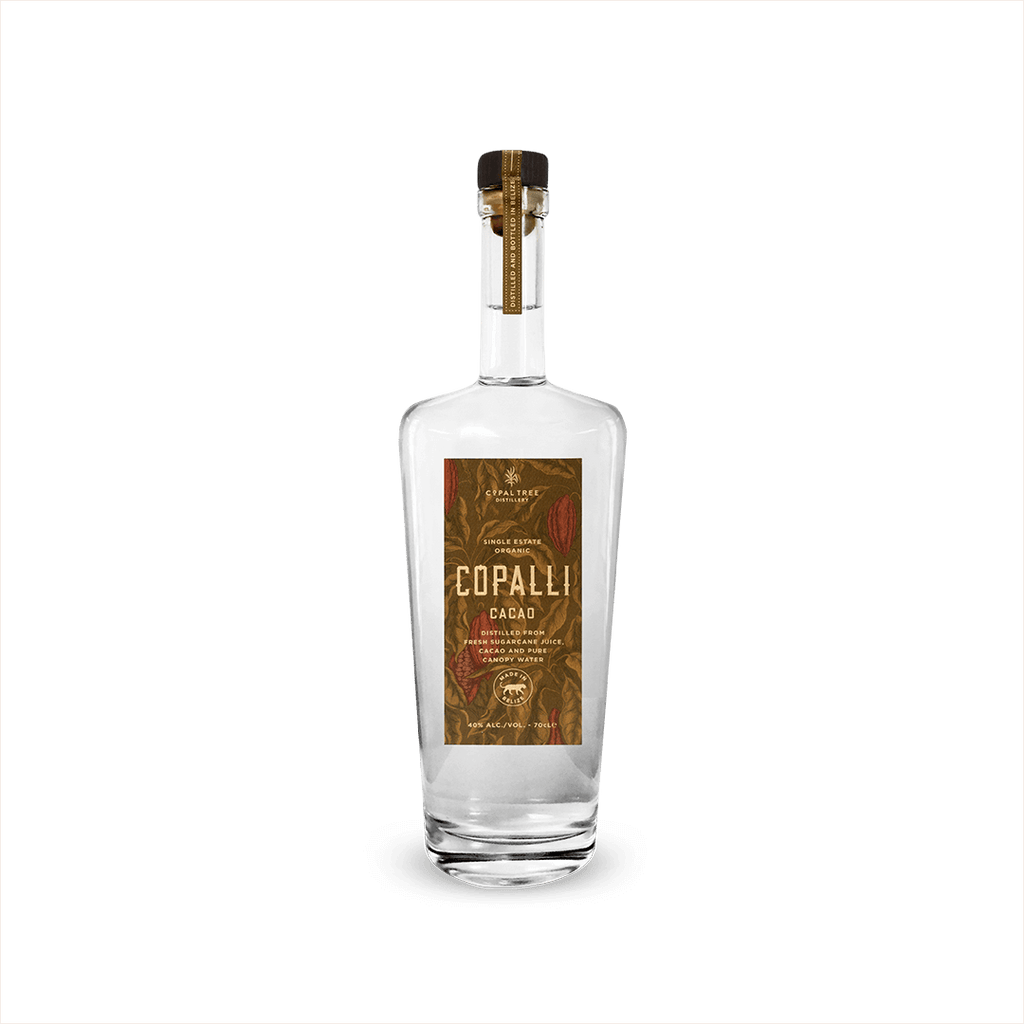 A tall elegant bottle of clear rum with a label that reads Copalli Cacao Single Estate Organic. The label, rich browns and reds, depicts cacao leaves and beans in illustration.